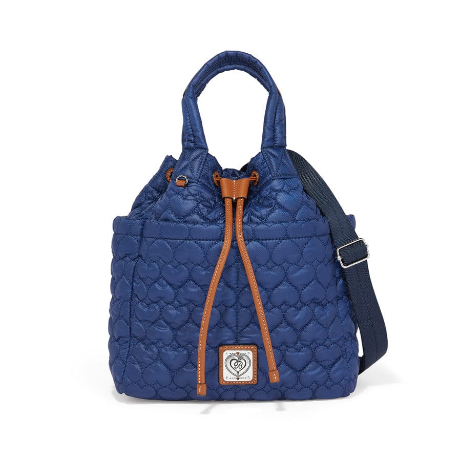 Front view of a Blue quilted Kenny Convertible Backpack a handbag with heart patterns and orange drawstrings is standing upright. It has short handles, a detachable shoulder strap with silver buckles, and a front logo plaque.