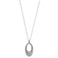 Back view of a Terra Blue Hoop silver necklace with an intricate, oval-shaped pendant featuring floral designs hangs from a simple chain against a white background.