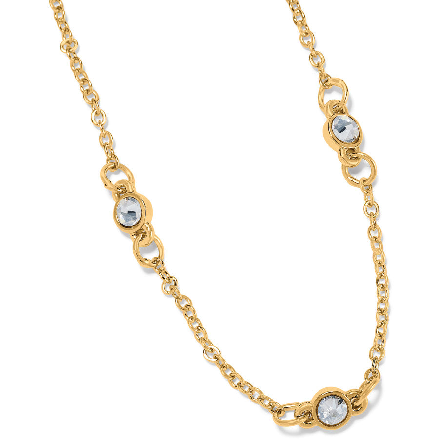 A gold necklace the Illumina Petite Collar Necklace with a delicate chain and symmetrically placed decorative elements, displayed against a plain background.