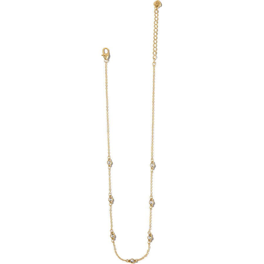 A Illumina Petite Collar gold necklace with embedded clear stones displayed against a neutral background.