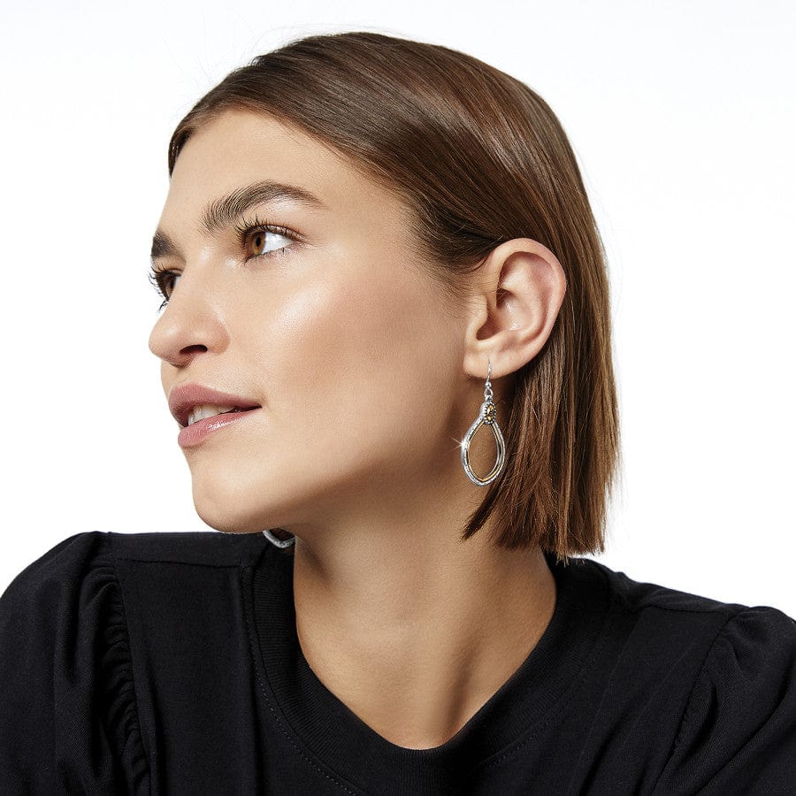 Woman wearing teardrop-shaped Venezia Teardrop French Wire Earrings, looking to the side against a white background, dressed in a black top.